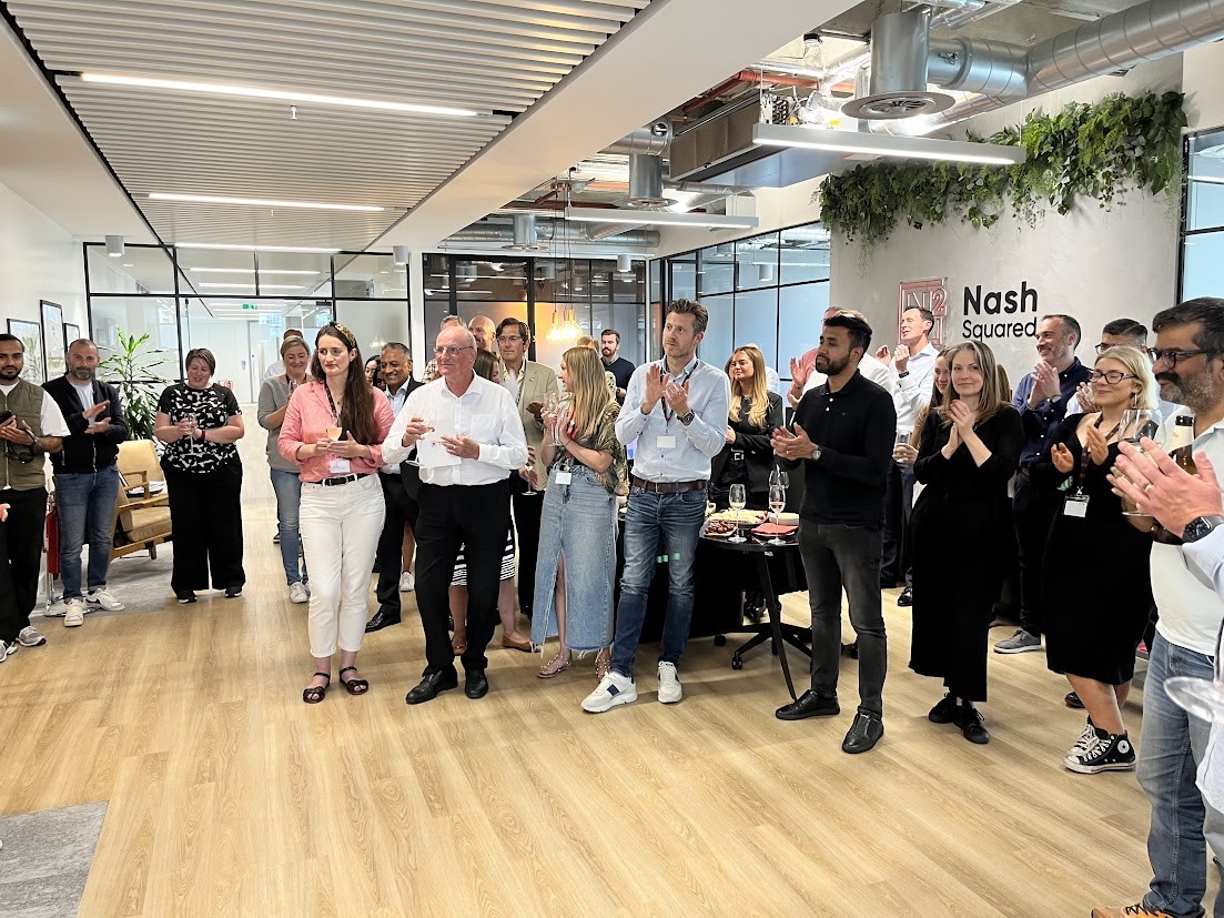 A group of people standing in a roomDescription automatically generated